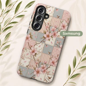 Op de afbeelding: Een Samsung telefoonhoesje met een patchworkontwerp van lichtroze, crèmekleurige en blauwgrijze vierkanten. Het patroon is bedekt met illustraties van bloeiende roze kersenbloesemtakken en kleine bruine vogels, met de tekst Samsung zichtbaar.