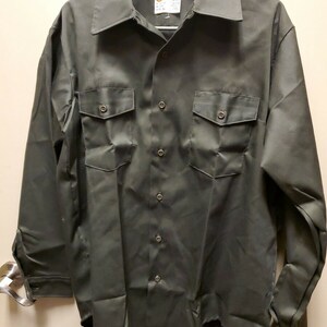 May include: A dark green long-sleeved button-down shirt with two chest pockets and a single button closure at the collar.