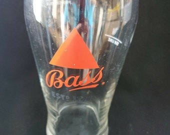 May include: A clear glass pint glass with a red triangle and the words "Bass" and "Est. 1777" printed on it.