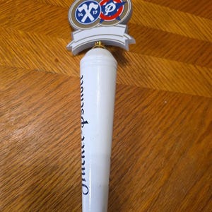 Op de afbeelding: Witte biertapkraanhendel met een decoratieve bovenkant met een logo met de nummers 14 en 17, en de tekst "Orion Beer" in blauw. De hendel is cilindrisch en heeft een schroefdraadbasis.