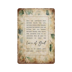 Puede incluir: Un letrero rectangular de metal con un fondo de papel envejecido y desgastado, con un borde de hojas de eucalipto verdes. El texto dice: FOR I AM CONVINCED THAT NEITHER DEATH NOR LIFE, NEITHER ANGELS NOR DEMONS, NEITHER THE LOVE OF GOD.