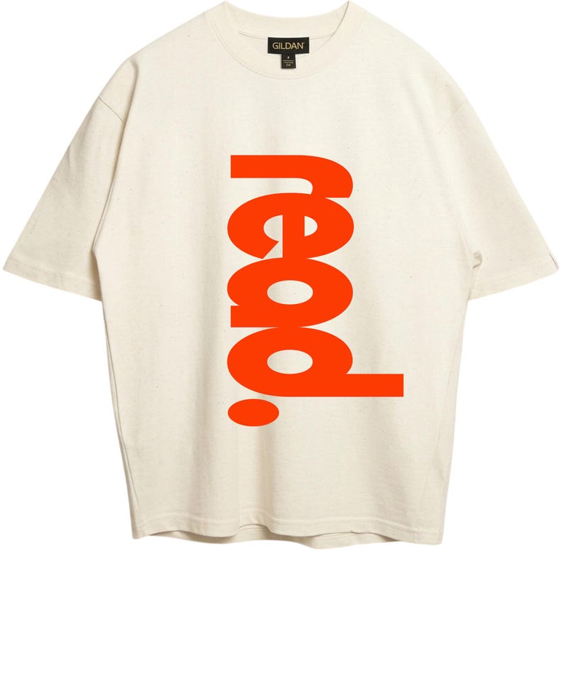 Puede incluir: Una camiseta de manga corta color blanco roto con la palabra read. impresa en letras grandes, negritas y verticales de color naranja en el centro. La prenda tiene cuello redondo y una etiqueta de la marca Gildan en el interior del cuello.