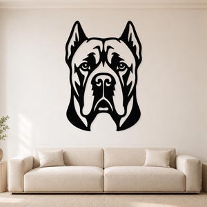 May include: A black metal wall art piece featuring a stylised, symmetrical portrait of a Cane Corso dog. The design uses bold, clean lines to define the facial features, ears, and snout of the dog, creating a high-contrast graphic silhouette.