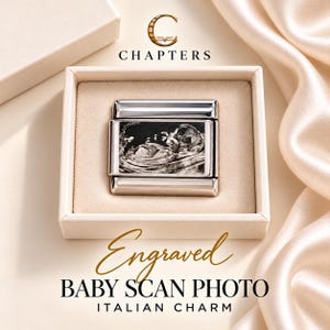 Puede incluir: Un charm italiano rectangular de tono plateado con una imagen grabada en blanco y negro de una ecografía de bebé. El charm se presenta en una caja cuadrada beige con el texto CHAPTERS, Engraved BABY SCAN PHOTO ITALIAN CHARM.