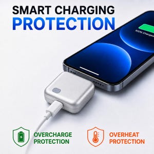 Puede incluir: Un cargador portátil cuadrado de color plateado conectado a un teléfono inteligente que muestra 100% de carga. El texto dice SMART CHARGING PROTECTION, OVERCHARGE PROTECTION y OVERHEAT PROTECTION. Los iconos incluyen una batería y un termómetro.