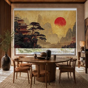 May include: A window roller shade featuring a printed landscape illustration of a traditional multi-story pagoda, dark pine trees, and jagged mountains set against a textured golden background with a large, vibrant red sun in the sky.