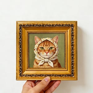 Ingwer-getigerte Katze mit Muschel-Punkten-Kopftuch auf gedecktem olivgrünem Hintergrund, Impasto-Ölgemälde, goldgerahmtes kleines quadratisches Wandbild