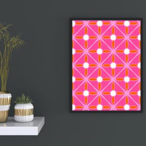 Puede incluir: Una lámina de arte mural rectangular en un marco negro con un patrón geométrico repetitivo de formas en rosa brillante, naranja vibrante y blanco. El diseño consiste en círculos blancos centrados dentro de pétalos naranjas sobre fondo rosa.
