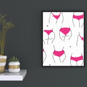 Puede incluir: Una lámina de arte mural enmarcada con un patrón repetitivo de dibujos de líneas negras que representan varios torsos inferiores con ropa interior de color rosa brillante sobre un fondo blanco, con pequeños corazones negros dispersos.