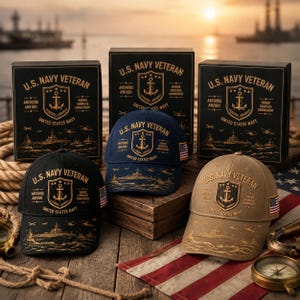 Puede incluir: Tres gorras de béisbol en negro, azul marino y beige, cada una con bordados dorados de un emblema de U.S. Navy Veteran, un barco y una bandera estadounidense en el lateral. Se presentan junto a cajas negras a juego con la misma etiqueta.