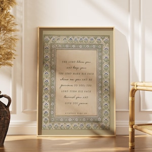 Könnte beinhalten: Ein rechteckiges gerahmtes Wandbild mit beigefarbenem Zentrum und dem Text "THE LORD bless you AND keep you; THE LORD MAKE HIS FACE shine on you AND BE gracious TO YOU; THE LORD TURN HIS FACE toward you AND GIVE YOU peace. NUMBERS 6:24-26", umgeben von einer floralen Bordüre in Grün-, Blau- und Weißtönen.
