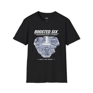 May include: A black short-sleeved t-shirt featuring a white graphic of an inline-six engine with turbocharger components. The text reads BOOSTED SIX, TURBOCHARGED-INLINE-6 CYLINDERS, and BUILT FOR BOOST in a clean, bold, sans-serif font centred on the chest.
