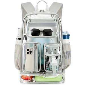 May include: A clear backpack with grey trim, featuring a large main compartment, a front zippered pocket, two smaller front pockets, and side mesh pockets. The bag contains sunglasses, a smartphone, pens, and a light green container at the base.