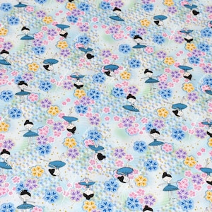 May include: A blue and white fabric with a repeating pattern of stylized ballerinas dancing among pink, purple, and yellow flowers. The background is a light blue with a subtle white pattern.