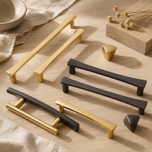 Peut inclure: Une collection de quincaillerie d'ameublement comprenant deux longues poignées dorées, deux longues poignées noir mat, une poignée bicolore or et noir, une poignée dorée simple et deux petits boutons triangulaires en finition or et noir mat.
