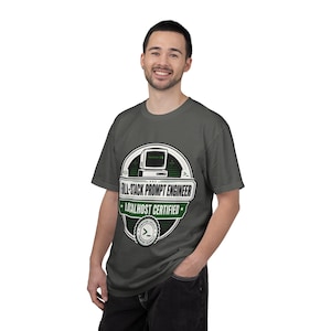 May include: A dark gray t-shirt featuring a circular graphic with a vintage computer icon, the text "FULL-STACK PROMPT ENGINEER" and "LOCALHOST CERTIFIED", along with a small "VERIFIED LOCALLY" badge containing a command line prompt symbol.