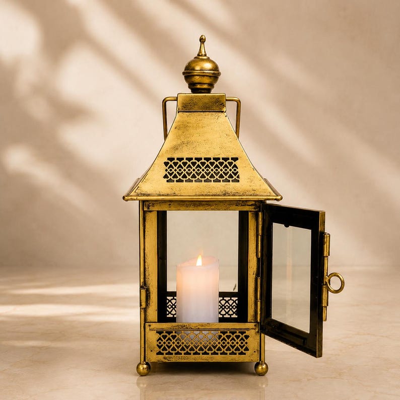 Handcrafted vintage brass finish metal lantern with clear glass panels and hanging loop, decorative candle holder for farmhouse, Moroccan, rustic home décor, weddings, patios, and festive celebrations.