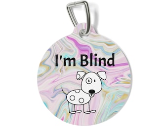 May include: A round pet tag with a swirling pink, blue, and gold marble pattern. The text "I'm Blind" is printed in black above a simple line-art illustration of a white dog with black spots and a single visible eye. A silver metal clip is attached.