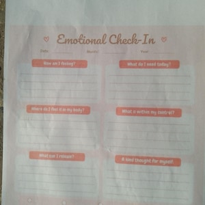 Könnte beinhalten: Ein gedrucktes Emotional Check-In Arbeitsblatt auf hellrosa Papier. Es enthält Abschnitte für Datum, Monat, Jahr und Fragen wie Wie fühle ich mich, Was brauche ich heute, Wo spüre ich es in meinem Körper, Was liegt in meiner Kontrolle, Was kann ich loslassen und Ein lieber Gedanke an mich selbst.