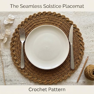 May include: A round, mustard-yellow crocheted placemat featuring a textured, scalloped edge. Centered on the placemat is a plain white ceramic plate, flanked by a silver fork on the left and a silver knife on the right. Text reads: The Seamless Solstice Placemat Crochet Pattern.