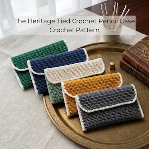May include: Five rectangular crochet pencil cases in green, navy blue, cream, mustard yellow, and dark grey, each featuring a white crocheted border. The text The Heritage Tied Crochet Pencil Case Crochet Pattern is visible above the items.