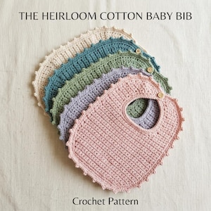 Puede incluir: Un conjunto de cinco baberos de ganchillo para bebé en colores crema, azul cerceta, verde salvia, lavanda y rosa empolvado. Cada babero tiene un borde festoneado y un pequeño botón de madera en el cuello. El texto THE HEIRLOOM COTTON BABY BIB es visible.