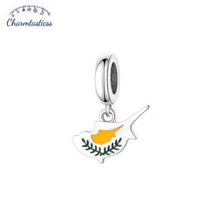 Op de afbeelding: Een zilveren bedel met een hangertje in de vorm van het eiland Cyprus. De hanger is voorzien van een gele emaille vulling en een groen emaille olijftakmotief. De bedel bevat een cilindervormig oogje voor bevestiging.