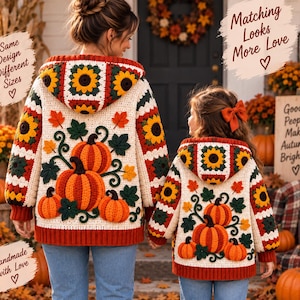 Puede incluir: Dos sudaderas con capucha de ganchillo color crema a juego con un patrón de cuadrados de la abuela de girasoles en la capucha y las mangas, con grandes calabazas naranjas y hojas verdes aplicadas en la espalda. Texto en la imagen: Same Design Different Sizes, Matching Looks More Love, Handmade with Love, Good People Make Autumn Brighter.