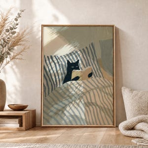 Puede incluir: Una lámina de arte enmarcada que muestra a un gato negro sentado en la cama bajo una colcha a rayas, sosteniendo un libro abierto. La ilustración utiliza una paleta de colores apagados en beige, crema y azul oscuro con texturas de pinceladas.
