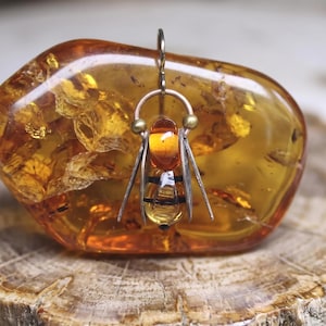 Amberkleurige glazen oorbellen met hommelmotief, sieraden met dierenmotieven en messing draadjes.