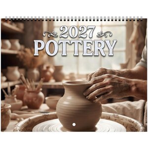May include: A 2027 wall calendar titled POTTERY featuring a spiral binding at the top. The cover displays a light brown clay vase being shaped on a pottery wheel, with various ceramic vessels visible on shelves in the blurred background.