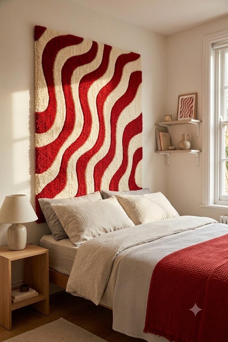 May include: A large rectangular wall hanging featuring a tufted texture with a repeating pattern of vertical wavy lines in alternating shades of deep red and cream. The textile piece is mounted on the wall above a bed with neutral bedding.