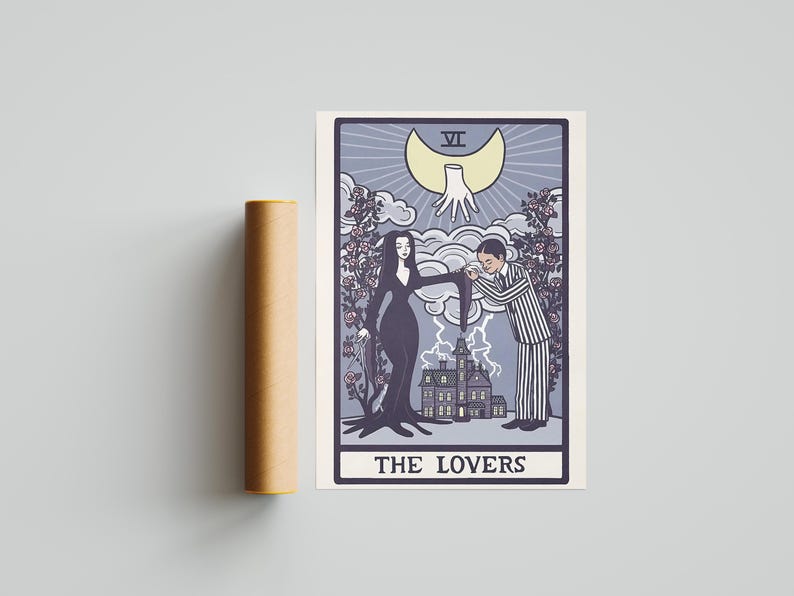 May include: A rectangular print featuring a tarot card design titled THE LOVERS, depicting a woman in a long black dress and a man in a striped suit standing before a house. Above them is a crescent moon with a hand, surrounded by rose bushes.