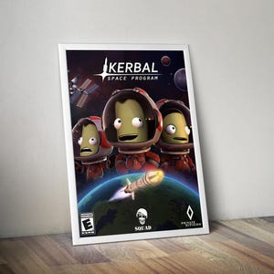 Może przedstawiać: Oprawiony plakat gry wideo Kerbal Space Program przedstawiający trzy zielonoskóre postacie w pomarańczowych skafandrach kosmicznych na tle ciemnej przestrzeni kosmicznej z rakietą startującą z planety, zawierający ocenę ESRB E oraz logotypy.