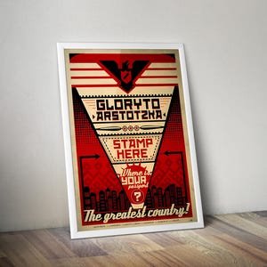 May include: A framed poster featuring a red, black, and cream graphic design. The text reads GLORY TO ARSTOTZKA, STAMP HERE, Where is YOUR passport?, and The greatest country!. It includes a central eagle emblem and a city skyline silhouette.