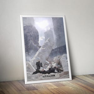 Peut inclure: Une affiche verticale encadrée présentant une illustration numérique de deux personnages en tenues noires se reposant au milieu de ruines en pierre blanche sous un ciel lumineux. Le texte NieR Automata 5th Anniversary est imprimé en bas au centre.