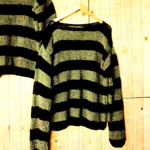 Handmade knit sweater with black and olive green stripes, featuring a loose fit and soft mohair blend, perfect for cozy alternative winter fashion.