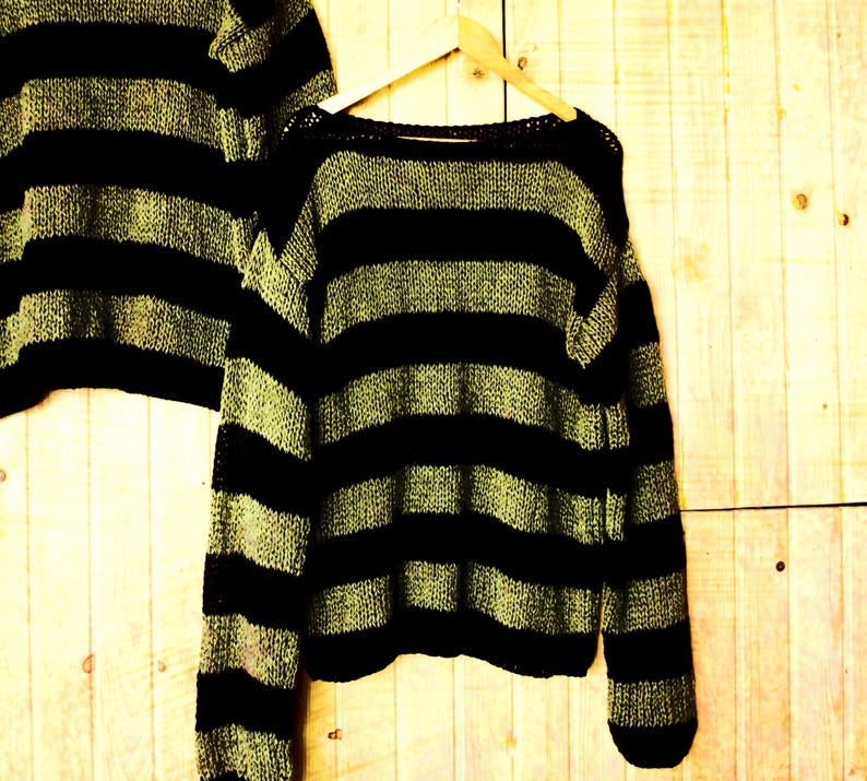 Handmade knit sweater with black and olive green stripes, featuring a loose fit and soft mohair blend, perfect for cozy alternative winter fashion.
