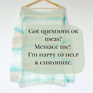 Op de afbeelding: Een trui met lange mouwen in lichtblauw, wit en beige hangt aan een houten hanger. De trui heeft een gestreept patroon. Tekst op de afbeelding luidt: "Vragen of idee&euml;n? Stuur me een bericht! Ik help graag en pas aan."