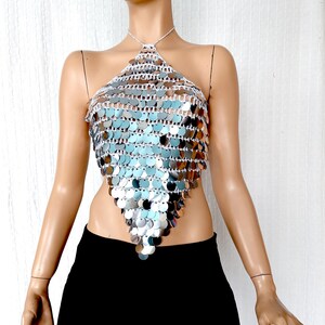 Statement halter top crafted with silver sequins and an open-knit base, forming a dramatic pointed triangle. Its bold metallic shine reflects light beautifully, ideal for styling at music festivals, disco-themed parties, or editorial fashion shoots.