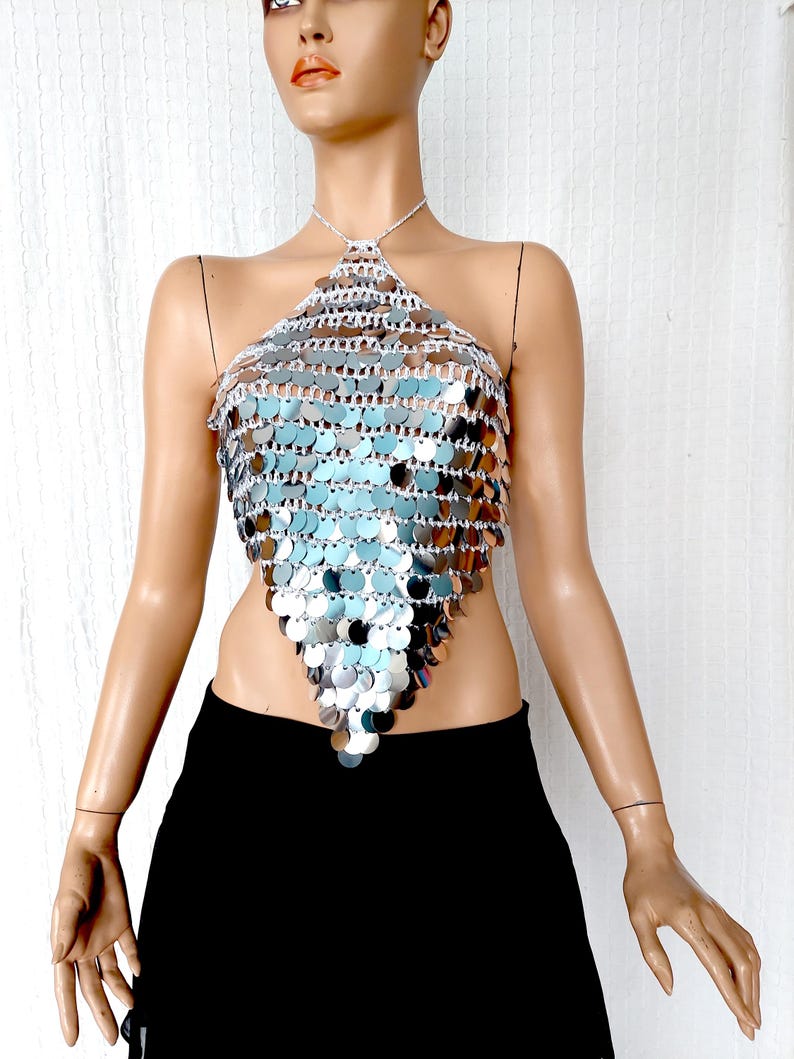Statement halter top crafted with silver sequins and an open-knit base, forming a dramatic pointed triangle. Its bold metallic shine reflects light beautifully, ideal for styling at music festivals, disco-themed parties, or editorial fashion shoots.