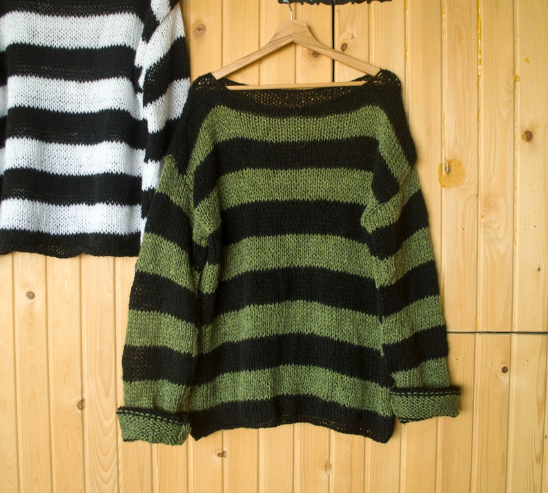 Striped grunge sweater in black and muted green tones, hand-knit with airy texture for unisex wearers who love edgy, laid-back styles.