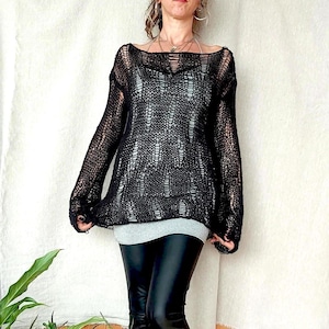 May include: Black crochet sweater with a loose fit and long sleeves. The sweater has a distressed look with holes throughout the fabric.