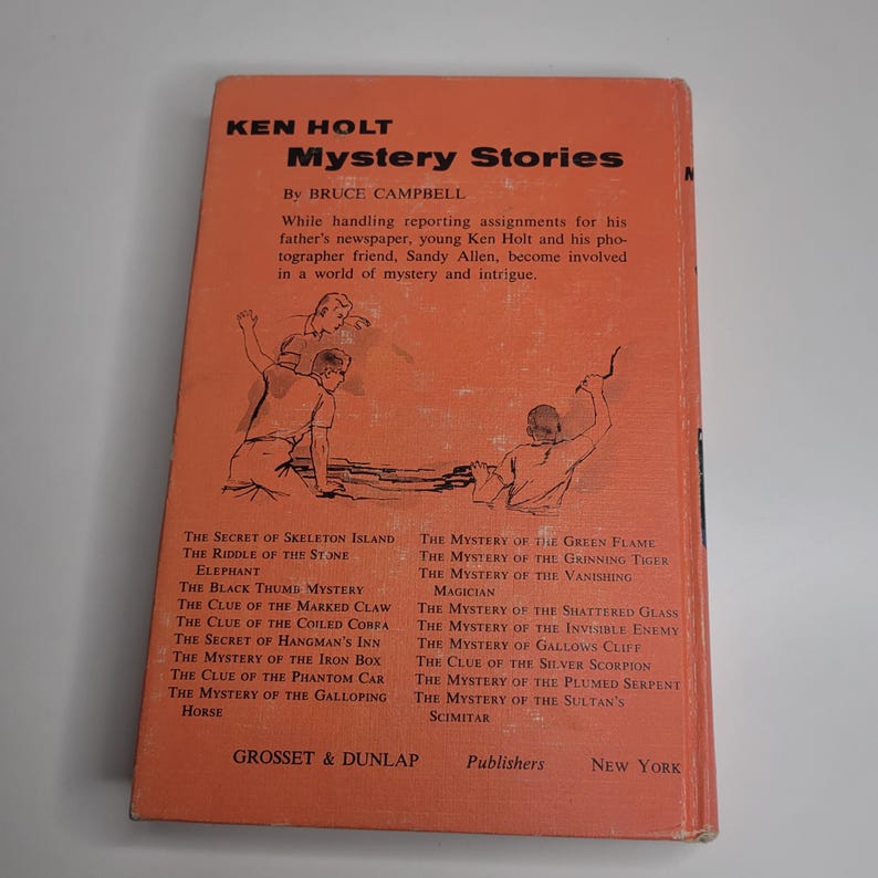 May include: Vintage hardcover book titled "Mystery Stories" by Bruce Campbell. The cover is orange with black text and illustrations. Features a list of mystery titles. Published by Grosset & Dunlap, New York.