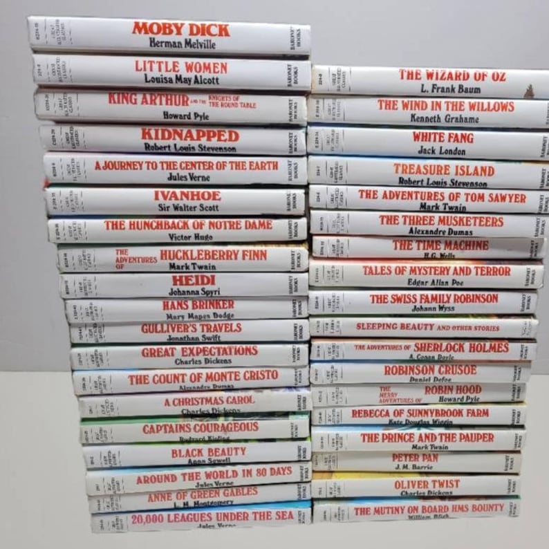 May include: A stack of 30 classic children's literature books with white spines and black text titles. The books are arranged vertically, with the titles facing forward. The titles include "Moby Dick", "Little Women", "King Arthur", "Kidnapped", "A Journey to the Centre of the Earth", "Ivanhoe", "The Hunchback of Notre Dame", "The Adventures of Huckleberry Finn", "Heidi", "Hans Brinker", "Gulliver's Travels", "Great Expectations", "The Count of Monte Cristo", "A Christmas Carol", "Captains Courageous", "Black Beauty", "Around the World in 80 Days", "Anne of Green Gables", "20,000 Leagues Under the Sea", "The Wizard of Oz", "The Wind in the Willows", "White Fang", "Treasure Island", "The Adventures of Tom Sawyer", "The Three Musketeers", "The Time Machine", "Tales of Mystery and Terror", "The Swiss Family Robinson", "Sleeping Beauty and Other Stories", "The Adventures of Sherlock Holmes", "Robinson Crusoe", "The Merry Adventures of Robin Hood", "Rebecca of Sunnybrook Farm", "The Prince and the Pauper", "Peter Pan", "Oliver Twist", "The Mutiny on Board HMS Bounty".
