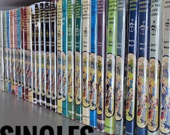 May include: A collection of 22 vintage paperback books with colourful covers featuring illustrations of children and animals. The books are titled "The Happy Hollisters" and each book has a different mystery to solve. The books are arranged on a shelf with the spines facing out.
