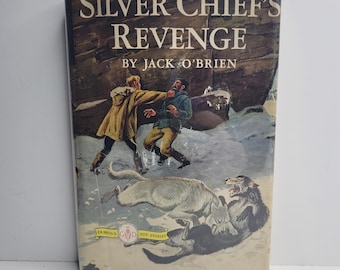 May include: Vintage book cover for "Silver Chief's Revenge" by Jack O'Brien. The cover art depicts two men in a snowy landscape, one punching the other. Two wolves are in the foreground. The book is part of the "Famous G&D Dog Stories" series.