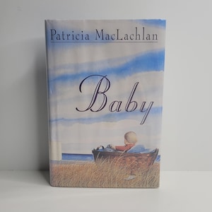 May include: A book titled "Baby" by Patricia MacLachlan. The cover features a watercolor illustration of a baby sitting in a basket on a beach.