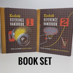 May include: A set of two vintage Kodak reference handbooks, one for black and white picture taking and the other for black and white processing and printing. The books are brown with yellow and red accents.