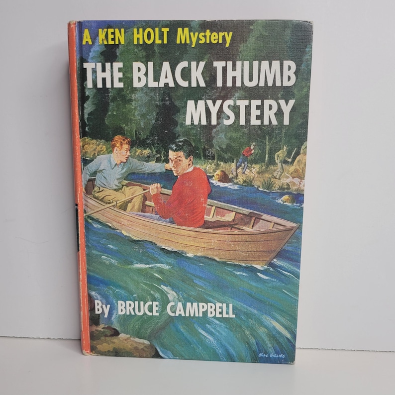 May include: Vintage hardcover book titled "The Black Thumb Mystery" by Bruce Campbell. The cover features an illustration of two young men in a rowboat on a river, with other figures in the background. The book has a red and orange spine.